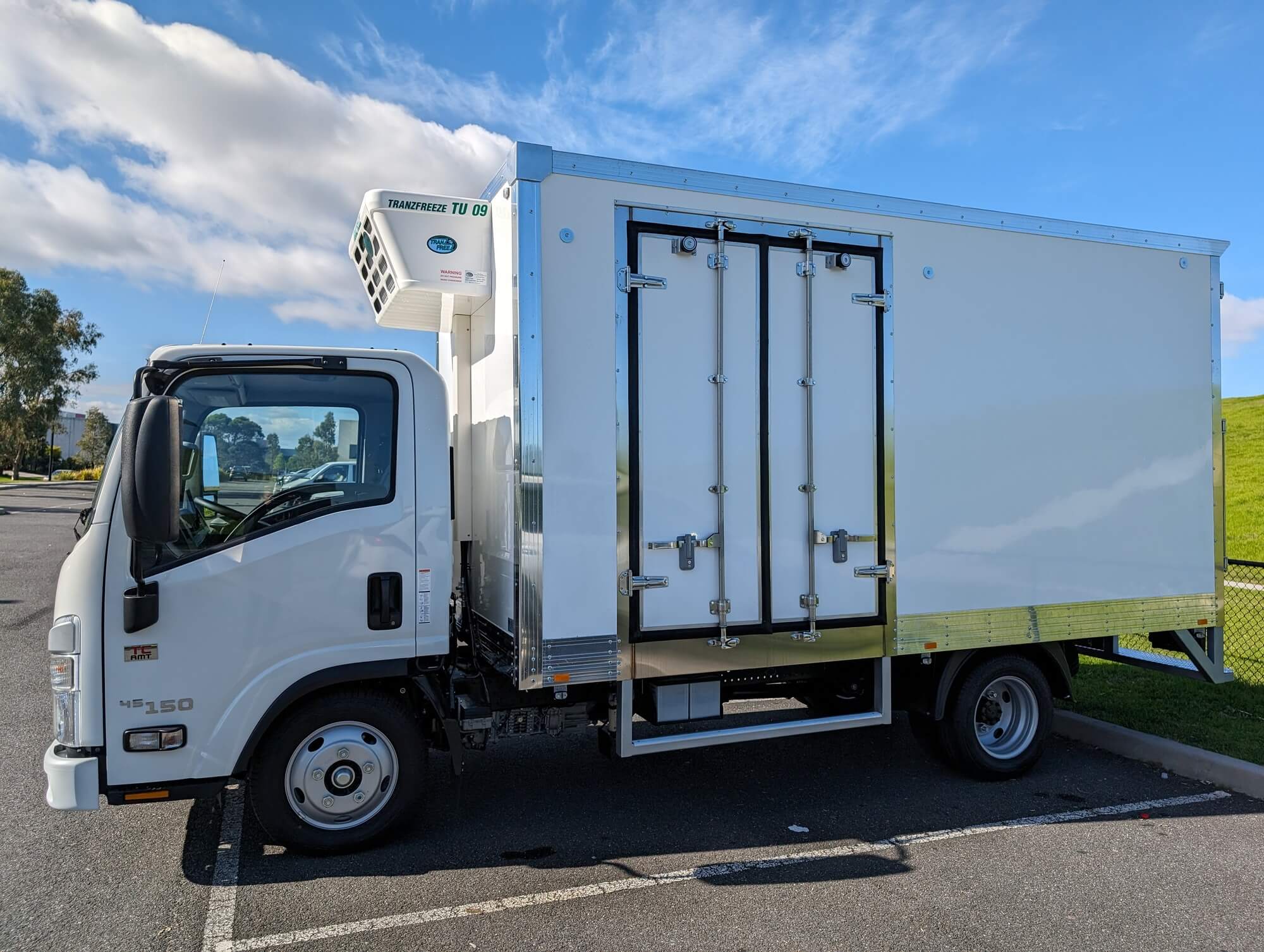 Isuzu NLR refrigerated truck with the side door open