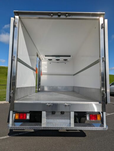 Checker plate floor inside a refrigerated truck body with the rear doors open
