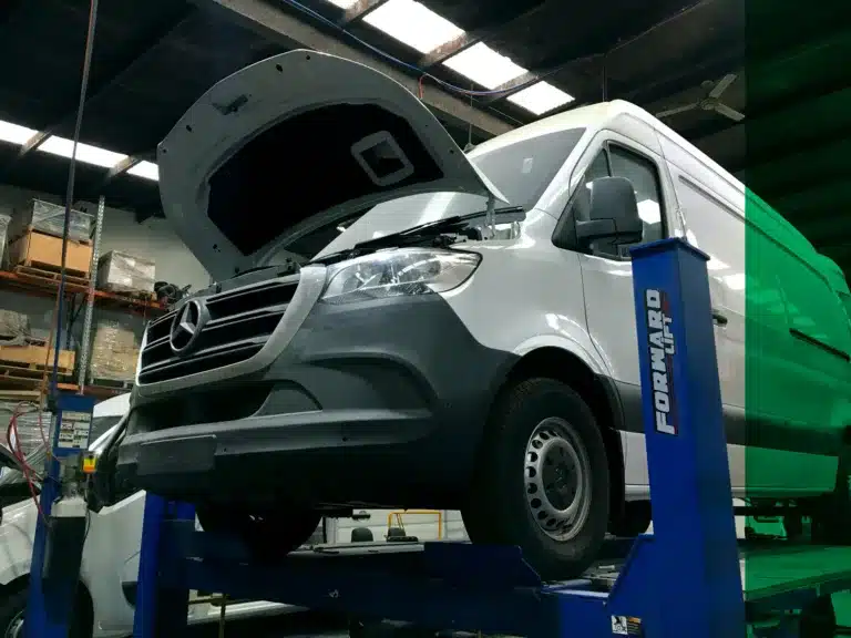 Mercedes-Benz Sprinter refrigerated van raised on a hoist for refrigeration servicing