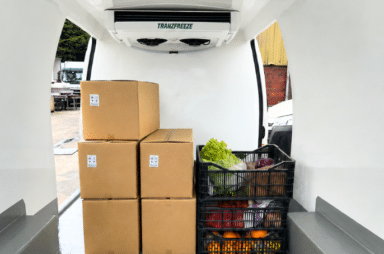 Refrigerated van interior loaded with produce boxes and crates